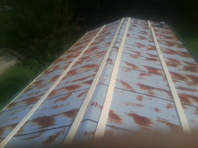 Rusted metal roof panels with new wood purlins before replacement — Storm Damage Roof Repair in Lanett by Roofing Brothers