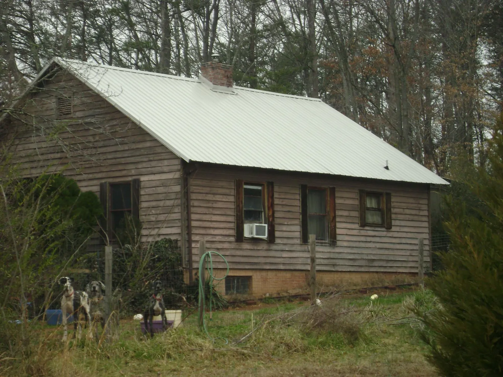 White metal roof on an old wood sided farmhouse, from a Metal Roof Installation job in Lanett
